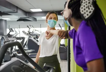 friends bumping elbows at fitness center