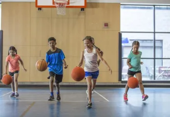 kids dribbling basketballs