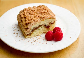 coffee cake on plate with raspberries