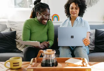 Two females looking at a computer. 