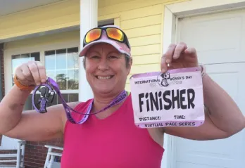 Tommiann Hill, a LIVESTRONG at the Y participant, with finisher race bib.