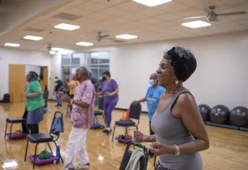 A SilverSneakers group exercise class at the Hayes-Taylor Y. A group of women are in a group exercise room.
