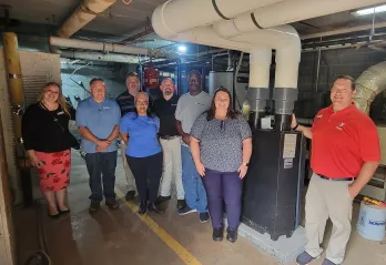 Weil-McLain and Eden Family Y staff in front of new boiler. 