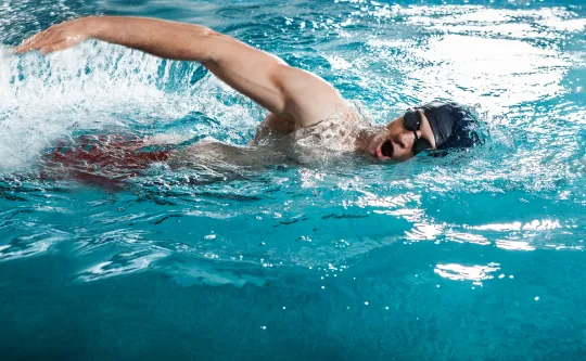 A man swims in a pool.