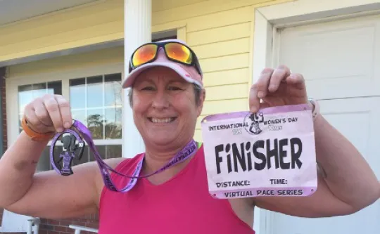 Tommiann Hill, a LIVESTRONG at the Y participant, with finisher race bib.