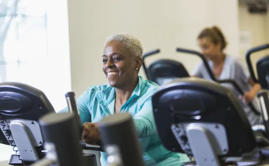 Senior african american woman at gym on exercise bike