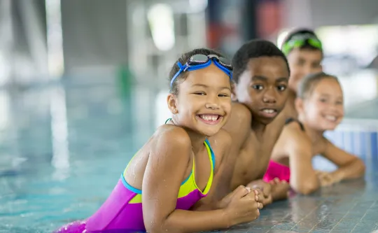 A group of young children swimming.