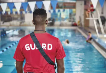 A YMCA lifeguard observes the pool.