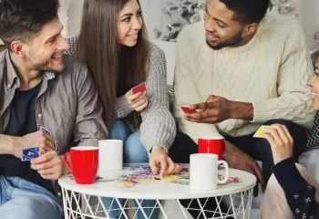 A diverse group of adults playing the card game Uno.