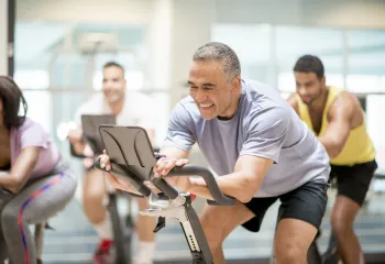 A man using a stationery bike at the gym.