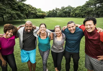 A group of people standing outside together and smiling at the camera.