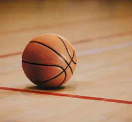 A basketball on a gymnasium floor.