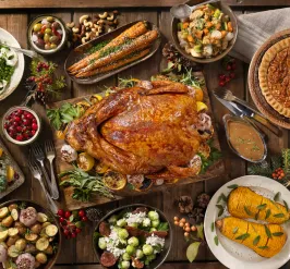 A holiday meal with a spread of foods like turkey, cranberries, and pies.