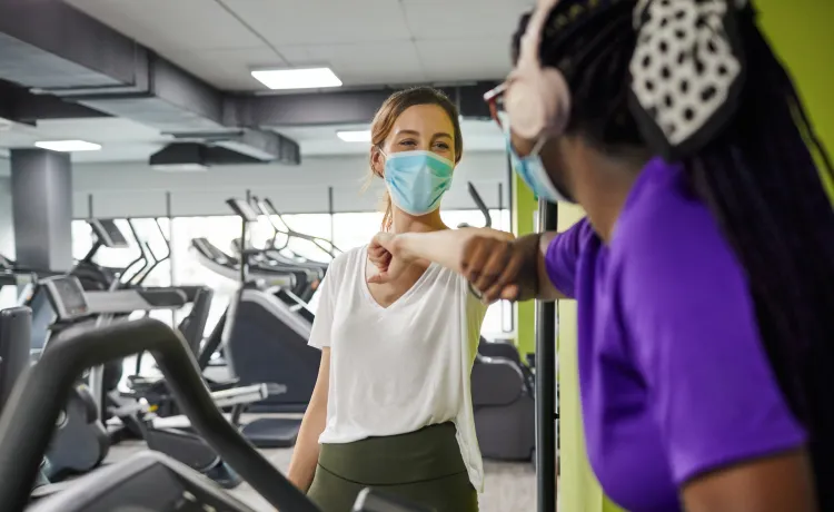 friends bumping elbows at fitness center