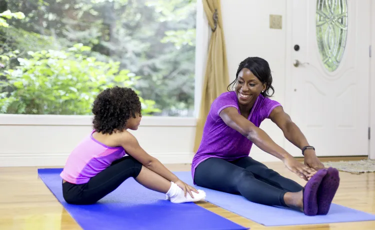 A mother and daughter stretching together.