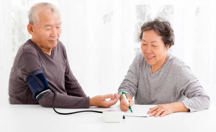 A senior couple monitoring their blood pressure at home.