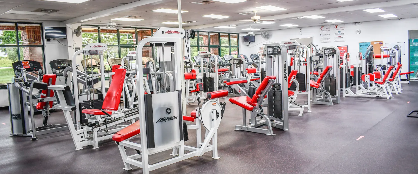 A photo of the Stoney Creek YMCA's fitness room. There are rows of exercise machines.