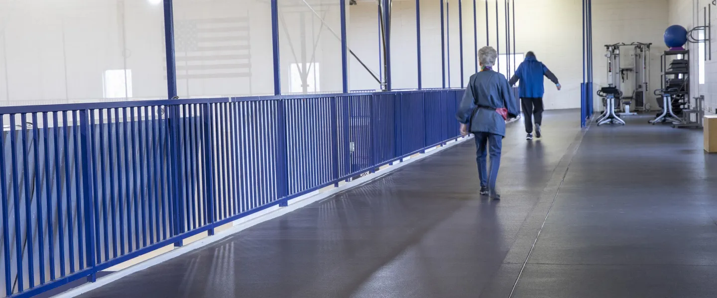 A photo of the walking track at the Ragsdale YMCA. Two figures are walking with their backs facing the camera.