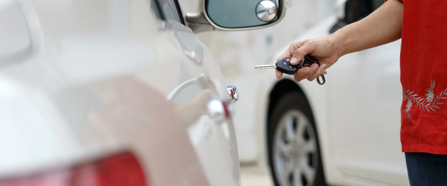 Person unlocking car with key.