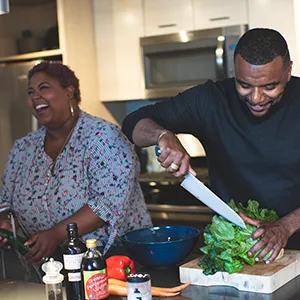 Couple cooking together and laughing. 