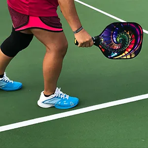 Person holding a pickleball paddle. 