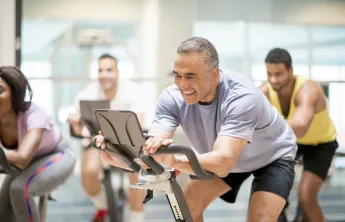 A man using a stationery bike at the gym.