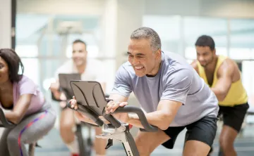 A man using a stationery bike at the gym.