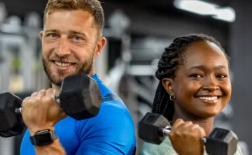 Man and woman side by side holding weights in their hand