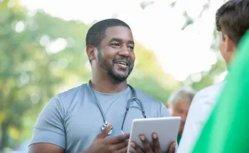 A doctor talks with a member of the community during a health fair event.